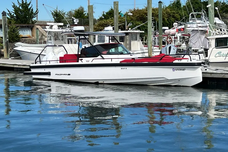  Yacht Photos Pics 2021 Axopar 28 boat docked at marina, featuring sleek design and red seating.