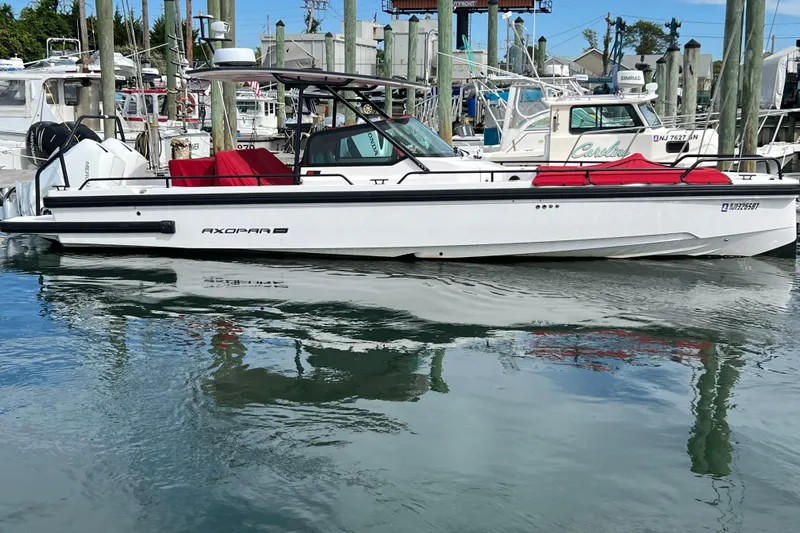  Yacht Photos Pics 2021 Axopar 28 boat docked in marina, featuring sleek design and red seating.