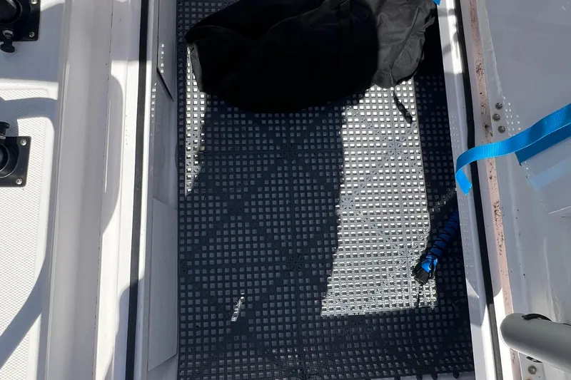  Yacht Photos Pics Storage compartment on a 2021 Axopar 28 boat with a black bag and blue strap.