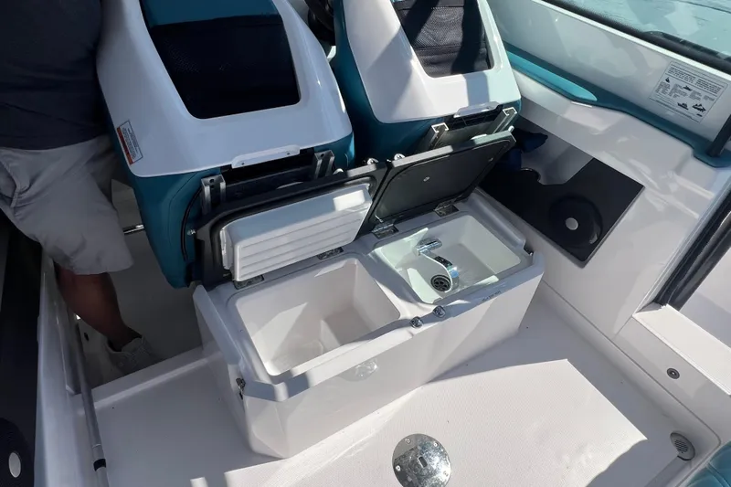  Yacht Photos Pics 2021 Axopar 28 boat interior with open storage compartment and sink.