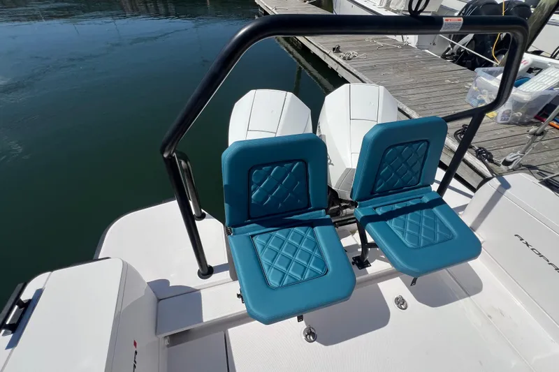  Yacht Photos Pics 2021 Axopar 28 boat with blue cushioned seats and dual engines at dock.
