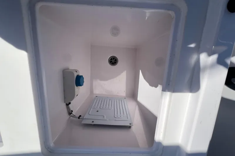  Yacht Photos Pics Storage compartment inside 2021 Axopar 28 boat, featuring drainage and electrical components.
