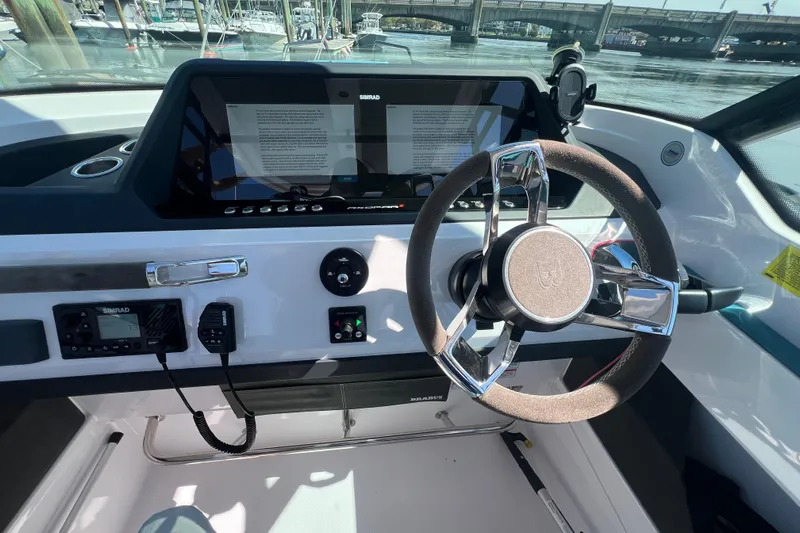  Yacht Photos Pics 2021 Axopar 28 boat dashboard with steering wheel and navigation controls.