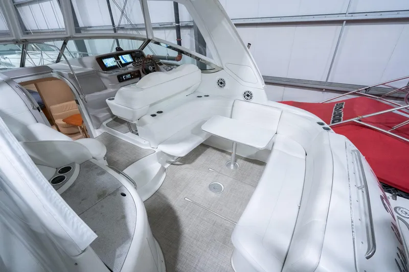 This Is Dope Yacht Photos Pics 2005 Formula 40 Cruiser interior with white seating and modern dashboard in a spacious cabin.