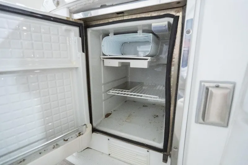 This Is Dope Yacht Photos Pics Open refrigerator inside a 2005 Formula 40 Cruiser boat, showing empty shelves.