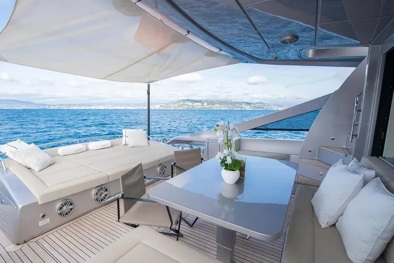  Yacht Photos Pics Luxurious 2021 Pershing 9X yacht deck with seating, table, and ocean view.