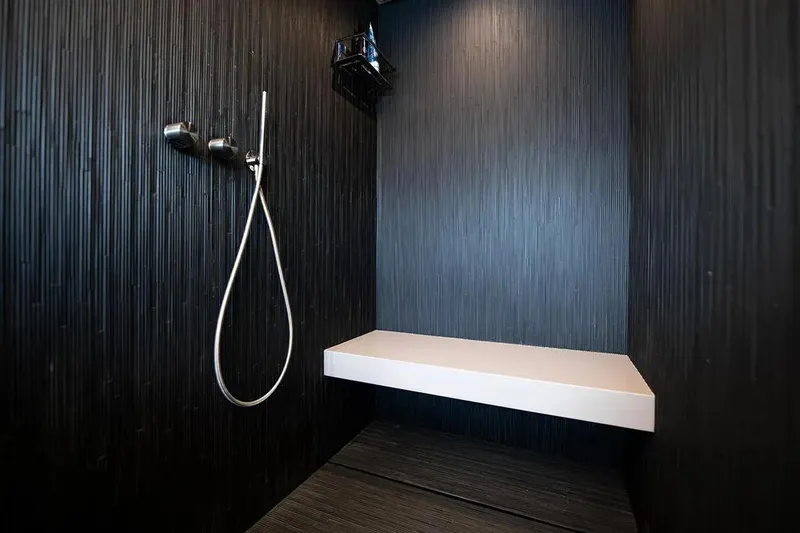  Yacht Photos Pics Modern shower with sleek black walls and minimalist design in a 2021 Pershing 9X yacht.