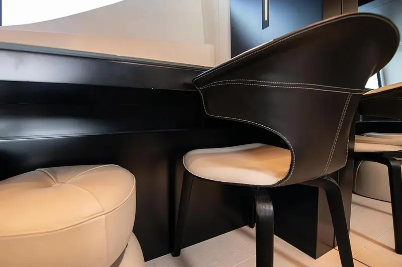  Yacht Photos Pics Luxurious interior seating on a 2021 Pershing 9X yacht, featuring elegant black and white design.