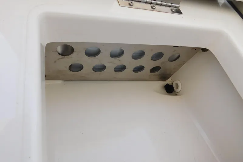  Yacht Photos Pics 2024 Pursuit DC 326 Dual Console storage compartment with metal ventilation panel.