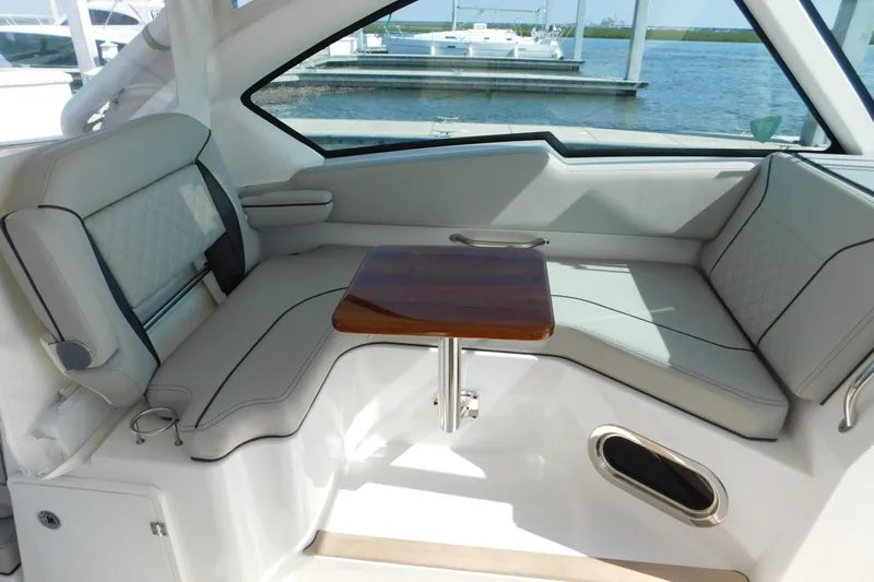  Yacht Photos Pics 2024 Pursuit DC 326 Dual Console interior with elegant seating and wooden table.