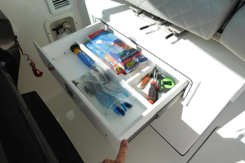  Yacht Photos Pics 2024 Pursuit DC 326 Dual Console storage drawer with tools and supplies.