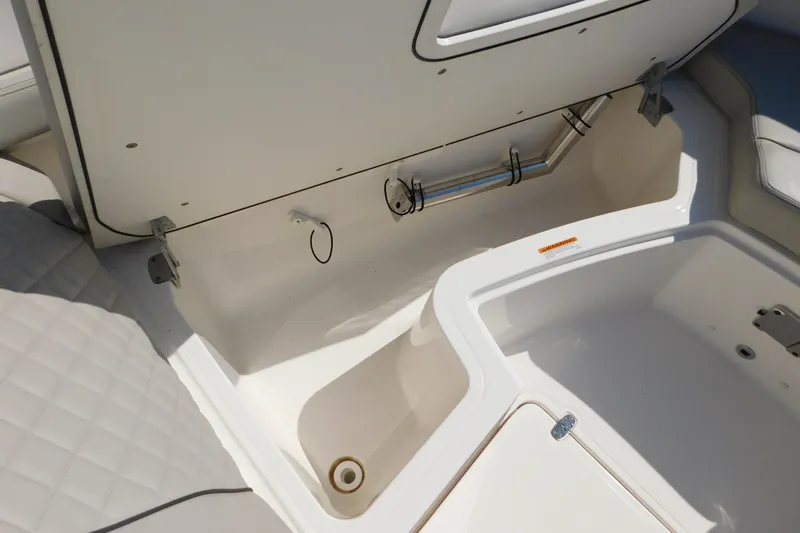  Yacht Photos Pics 2024 Pursuit DC 326 Dual Console storage compartment with open lid, showcasing interior space.