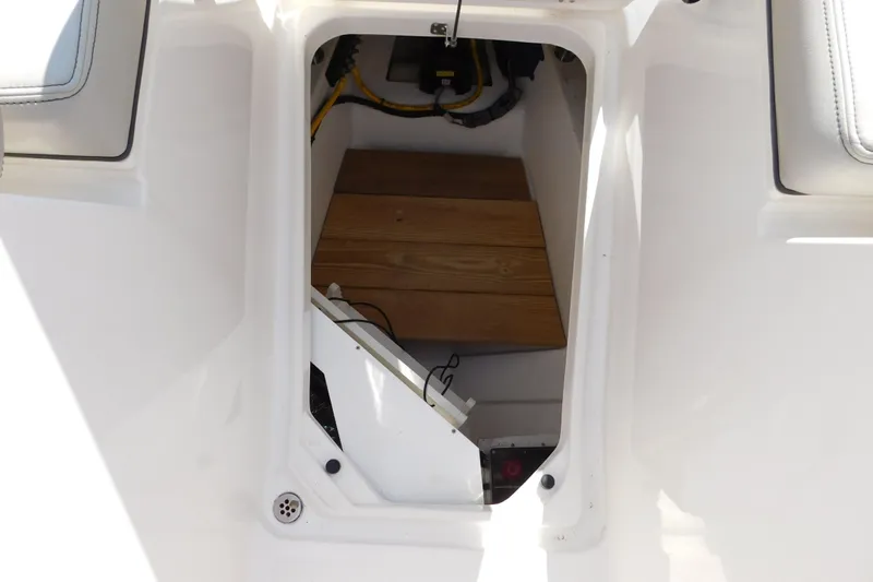  Yacht Photos Pics 2024 Pursuit DC 326 Dual Console interior storage compartment with wooden flooring.