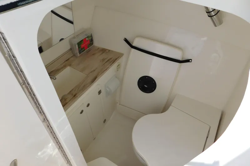  Yacht Photos Pics 2024 Pursuit DC 326 Dual Console boat bathroom with sink, toilet, and first aid kit.