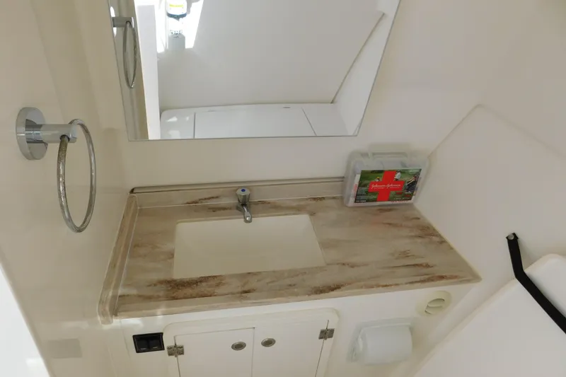  Yacht Photos Pics 2024 Pursuit DC 326 Dual Console bathroom with sink, mirror, and first aid kit.
