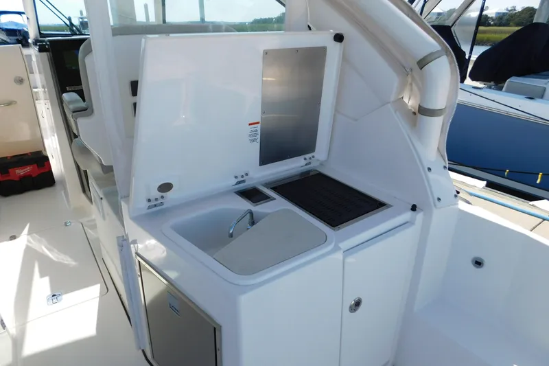  Yacht Photos Pics 2024 Pursuit DC 326 Dual Console boat interior with sink and storage area.