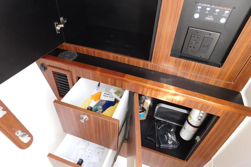  Yacht Photos Pics 2024 Pursuit DC 326 Dual Console interior storage with wooden cabinetry and control panel.