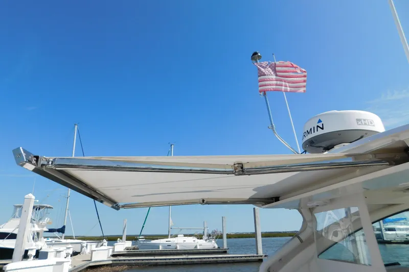  Yacht Photos Pics 2024 Pursuit DC 326 Dual Console boat with radar and American flag at marina.