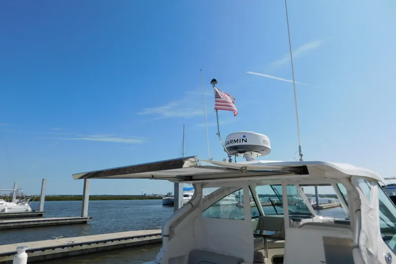  Yacht Photos Pics 2024 Pursuit DC 326 Dual Console boat docked with American flag and Garmin radar.