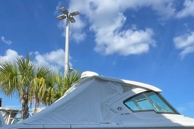  Yacht Photos Pics 2024 Pursuit DC 326 Dual Console boat under clear blue sky with palm trees.