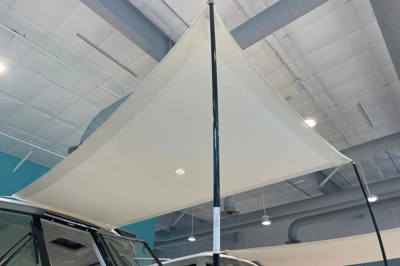  Yacht Photos Pics 2024 Pursuit DC 326 Dual Console boat with a large sunshade canopy indoors.