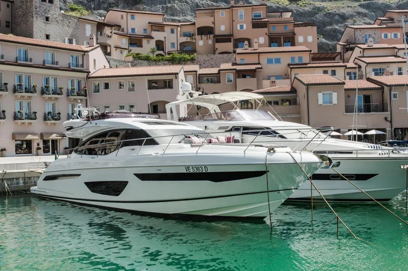  Yacht Photos Pics Luxury 2018 Princess S65 yacht docked in scenic marina with charming buildings.