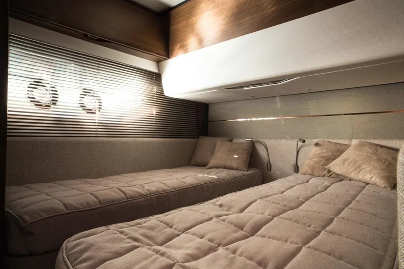  Yacht Photos Pics Luxurious twin cabin interior of 2018 Princess S65 yacht with elegant bedding and porthole windows.