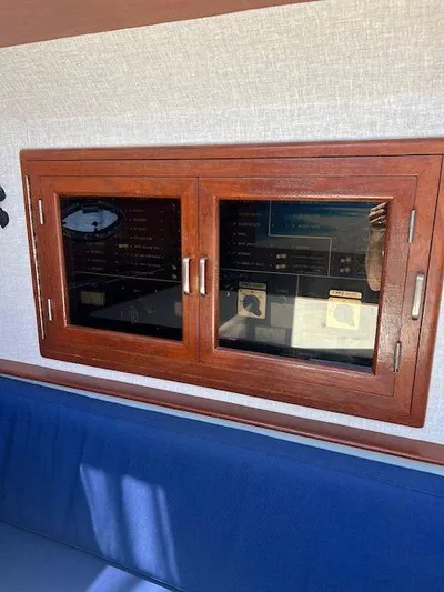Ronda-vous Yacht Photos Pics 1990 Jefferson 42 Viscount Sundeck interior with wooden cabinet and blue seating.