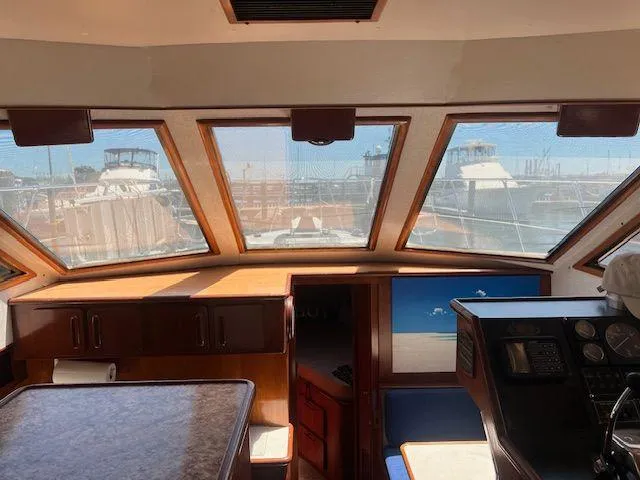 Ronda-vous Yacht Photos Pics Interior view of 1990 Jefferson 42 Viscount Sundeck yacht with large windows and control panel.