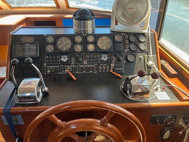 Ronda-vous Yacht Photos Pics 1990 Jefferson 42 Viscount Sundeck helm with gauges, controls, and wooden steering wheel.