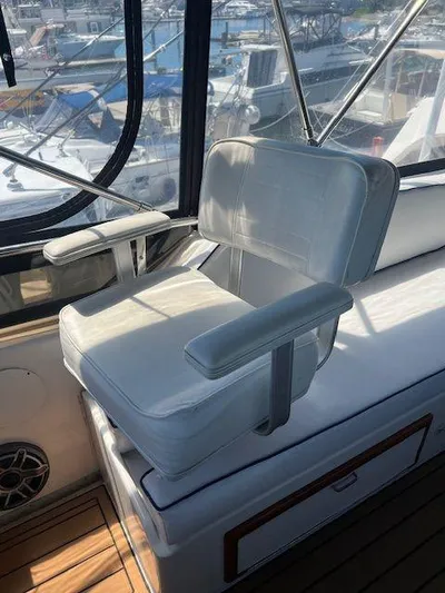 Ronda-vous Yacht Photos Pics Captain's chair on 1990 Jefferson 42 Viscount Sundeck yacht, with marina view.