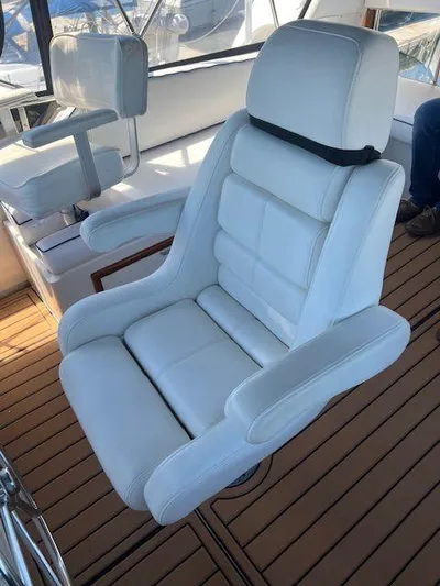 Ronda-vous Yacht Photos Pics White captain's chair on 1990 Jefferson 42 Viscount Sundeck, teak flooring background.