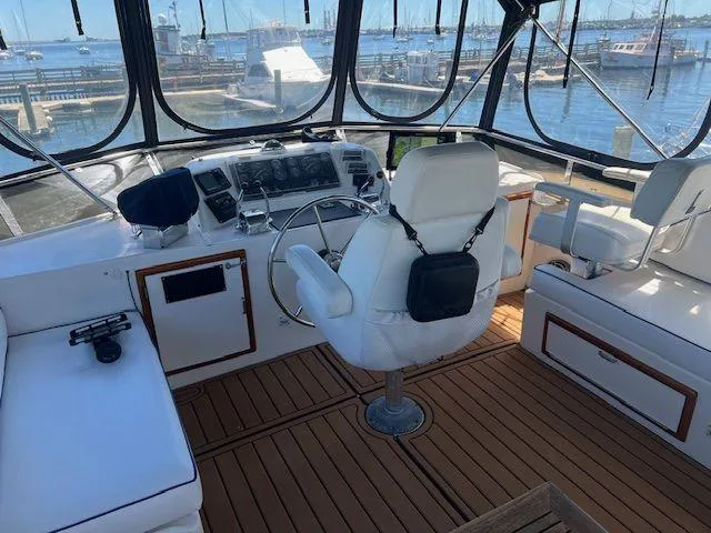 Ronda-vous Yacht Photos Pics Helm of 1990 Jefferson 42 Viscount Sundeck with white seating and wooden flooring.
