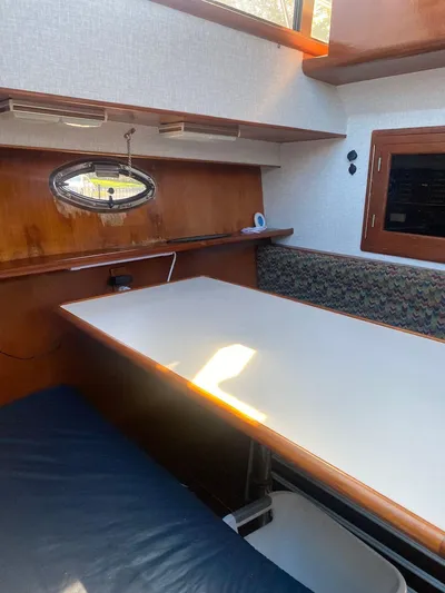 Ronda-vous Yacht Photos Pics 1990 Jefferson 42 Viscount Sundeck interior with table, seating, and porthole window.