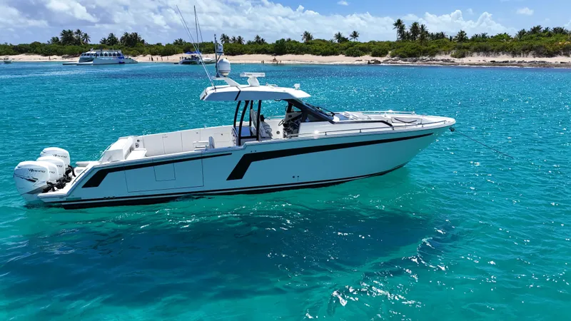  Yacht Photos Pics 2020 Ocean Alexander 45 Divergence Sport boat on clear turquoise water near a tropical beach.