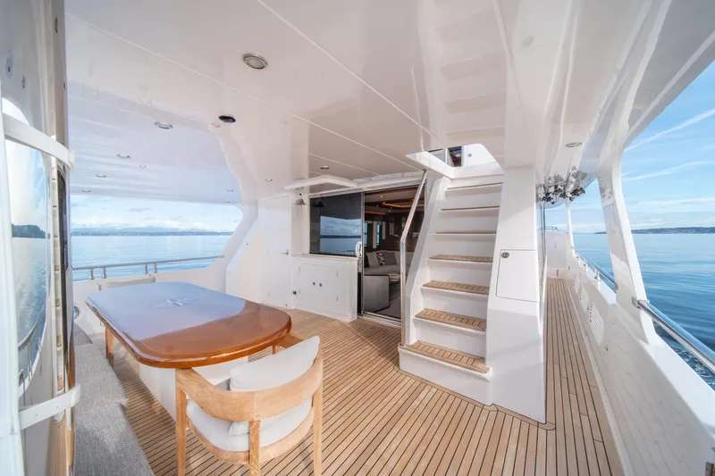 750 Skylounge Yacht Photos Pics Luxurious 2022 Hampton Endurance 750 LRC yacht deck with dining area and ocean view.