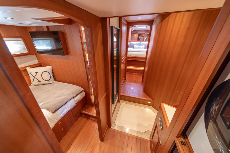 750 Skylounge Yacht Photos Pics Luxurious interior of 2022 Hampton Endurance 750 LRC yacht with wood paneling and cozy bedding.