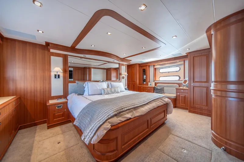 750 Skylounge Yacht Photos Pics Luxurious bedroom interior of 2022 Hampton Endurance 750 LRC yacht with elegant wood finishes.