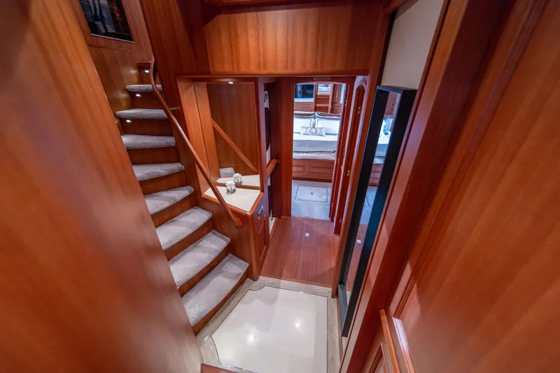 750 Skylounge Yacht Photos Pics Luxurious wooden interior of 2022 Hampton Endurance 750 LRC yacht with staircase and hallway.