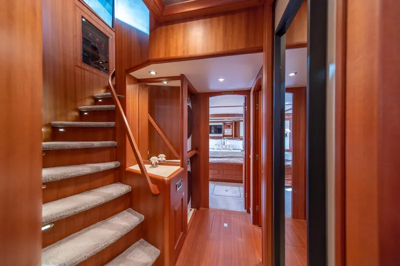 750 Skylounge Yacht Photos Pics Interior of 2022 Hampton Endurance 750 LRC yacht, featuring elegant wood paneling and staircase.