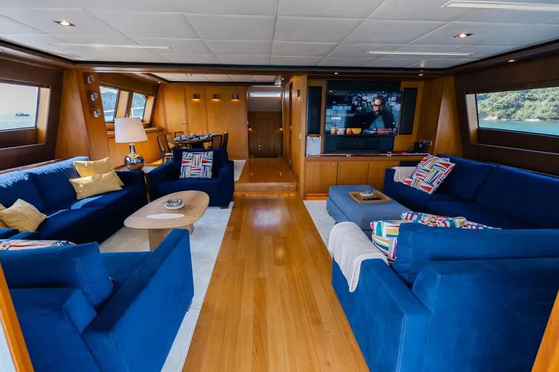 Mare Blu Yacht Photos Pics Luxurious interior of 2008 Pro Boat Yachts Power Cat 80 with blue sofas and wooden accents.