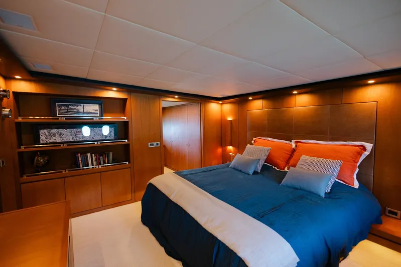 Mare Blu Yacht Photos Pics Luxurious bedroom in 2008 Pro Boat Yachts Power Cat 80, featuring elegant wood paneling and cozy bedding.