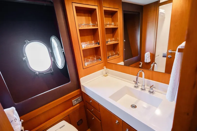 Mare Blu Yacht Photos Pics Luxurious bathroom in 2008 Pro Boat Yachts Power Cat 80, featuring modern fixtures and wood cabinetry.