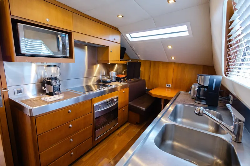 Mare Blu Yacht Photos Pics Luxurious kitchen interior of 2008 Pro Boat Yachts Power Cat 80, featuring modern appliances and wood cabinetry.