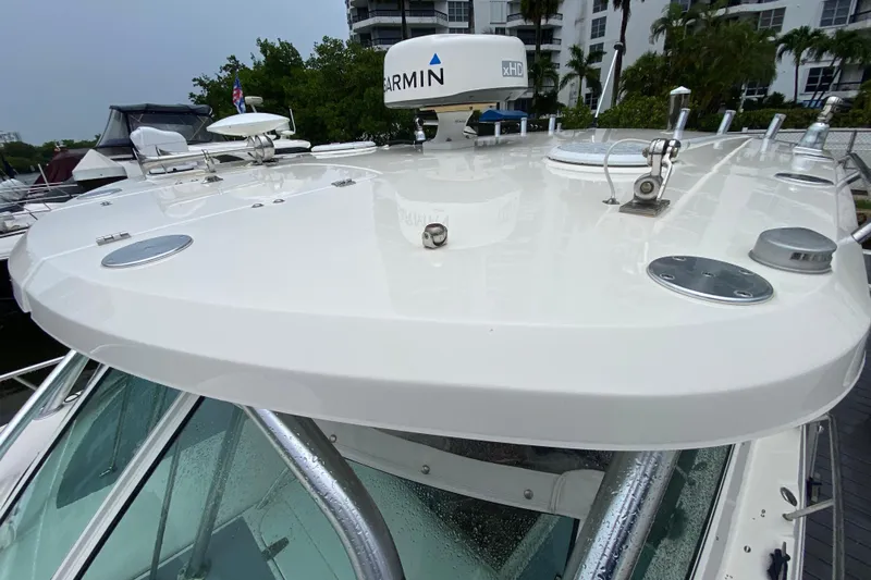  Yacht Photos Pics 2014 Wellcraft 340 Coastal boat with Garmin radar, docked near lush greenery.