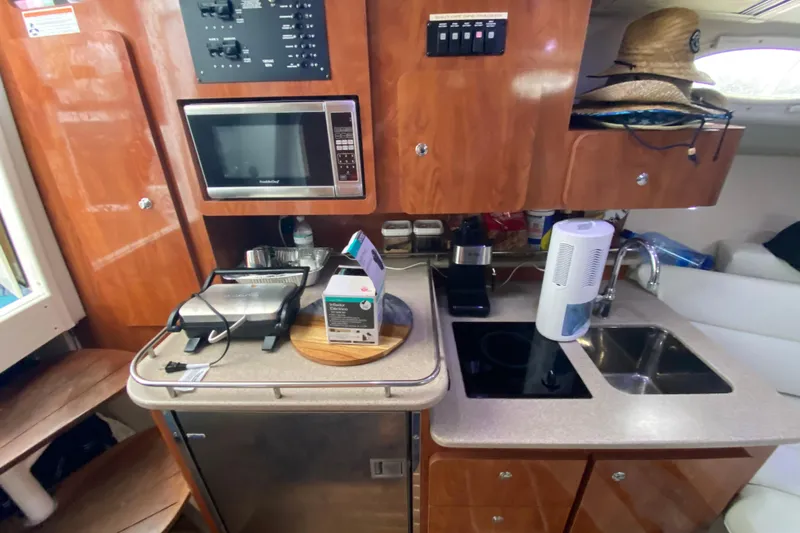 Yacht Photos Pics 2014 Wellcraft 340 Coastal boat kitchen with microwave, sink, and appliances.