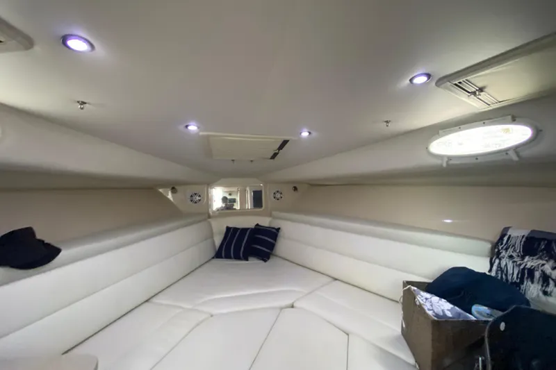  Yacht Photos Pics Interior cabin of 2014 Wellcraft 340 Coastal boat, featuring white seating and ambient lighting.