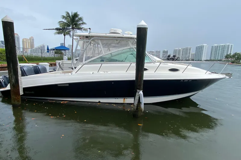  Yacht Photos Pics 2014 Wellcraft 340 Coastal boat docked in a marina with cityscape background.