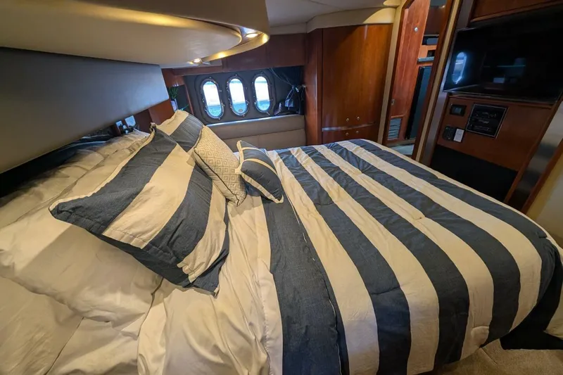  Yacht Photos Pics Luxurious bedroom interior of 2007 Cruisers Yachts 520 Express with striped bedding.