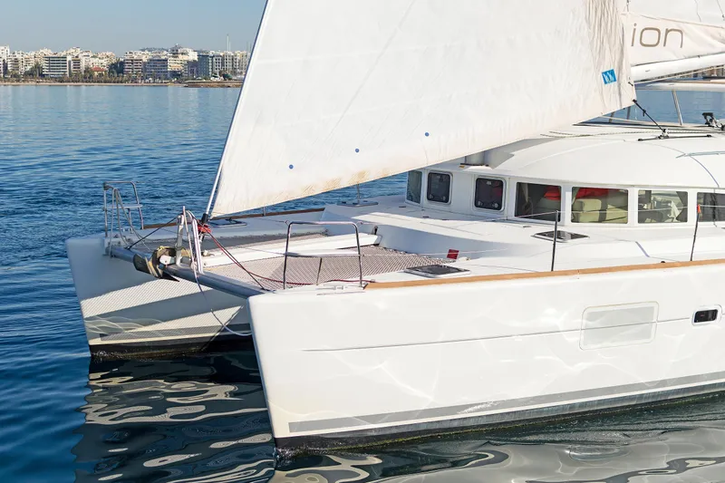 Cataki Yacht Photos Pics 2017 Lagoon 380 S2 catamaran sailing near urban coastline.